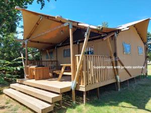 a gazebo with a deck with a picnic structure at Glamping Essenhof in Aagtekerke