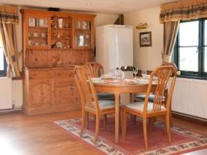a kitchen with a table and chairs and a refrigerator at Paddock Barn ~ Short & Long term stay, pets welcome ~ Woodbridge, Framlingham ar in Cretingham