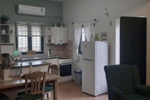 a kitchen with a white refrigerator and a table at Cottage Meraki in Káto Kalésia