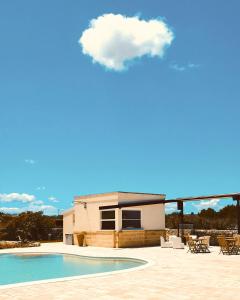una nuvola sopra una casa con piscina di Agriturismo Le Site a Corigliano dʼOtranto