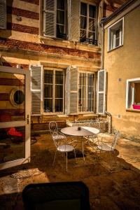 a table and chairs in front of a building at Demeure D'Argonne in Sainte-Menehould