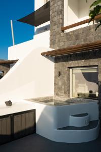a white house with a staircase and a window at Santa Mar ECO Suites in Karterados