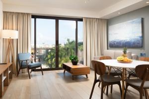 una sala de estar con mesa y sillas y una habitación en Tú Paraiso Privado- Lahun Suites Playa del carmen, en Playa del Carmen