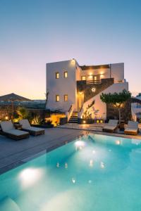 a villa with a swimming pool in front of a building at Santa Mar ECO Suites in Karterados