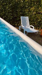 einen Sessel neben einem Pool in der Unterkunft Casa Vacanze Il Sole in Casamassella