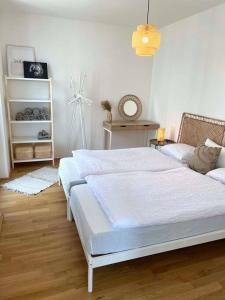a white bedroom with a bed and a couch at Donaublick Oasis: Stylische Wohnung in Vienna