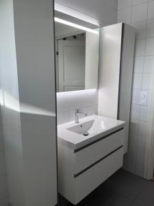 bagno bianco con lavandino e specchio di Havsnära nyrenoverat centralt i Båstad a Båstad