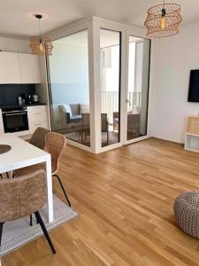 uma sala de estar com mesa e cadeiras e uma cozinha em Donaublick Oasis: Stylische Wohnung em Viena