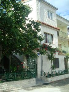 una casa blanca con una puerta y un árbol en Apartmani Daria & Jure en Trogir