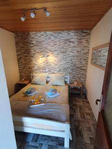 1 dormitorio con cama y pared de ladrillo en Apartmani Daria & Jure en Trogir