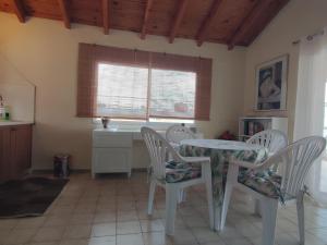 cocina con mesa, sillas y ventana en Sunset Terrace - Spacious apartment in Nea Plagia, en Nea Plagia