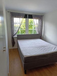 een bed in een slaapkamer met een raam bij Havsnära nyrenoverat centralt i Båstad in Båstad