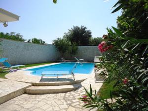 una piscina con mesa y sillas en un patio en Villa Dafne, en Bari