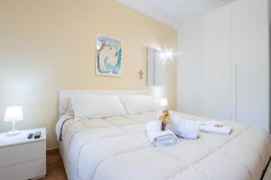 a bedroom with a large white bed with towels on it at Anthea Apartment in Palermo