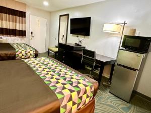 Habitación de hotel con 2 camas y escritorio en Magnolia Motel Donaldsonville, en Donaldsonville