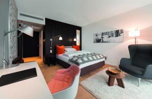 ロイトリンゲンにあるアチャーム ホテルのベッドルーム1室(ベッド1台付)、リビングルームが備わります。