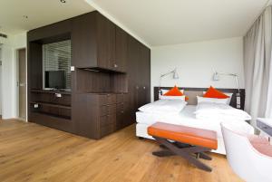 a bedroom with a bed with orange pillows and a television at Achalm Hotel in Reutlingen