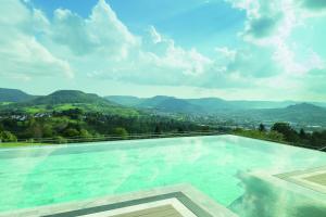 a swimming pool with a view of the mountains at Achalm Hotel in Reutlingen