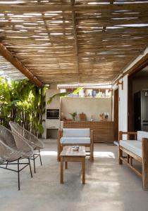 d'un salon avec des chaises, une table et un sidx de table. dans l'établissement Casa das Corujas, à Praia do Espelho