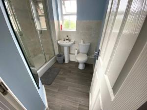 a bathroom with a white toilet and a sink at Modern Penthouse in Wellingborough +9 photos