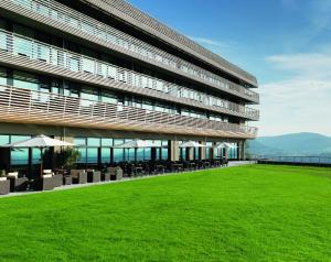 un grand bâtiment avec une pelouse verte devant lui dans l'établissement Achalm Hotel, à Reutlingen