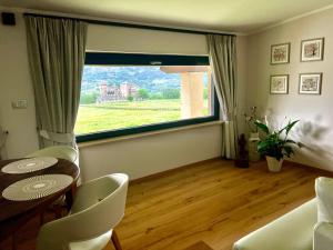 a living room with a table and chairs and a large window at La Rose du Prevot in Fenis