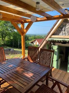 a wooden table and chairs on a wooden deck at Csendár Cottage Balaton in Hegymagas