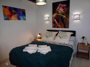 1 dormitorio con 1 cama con 2 toallas en Le Scoubidou, en Perpiñán