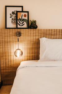a bed with a wooden headboard with a light above it at LOFTS by Elegant Hospitality - across AUC in Cairo