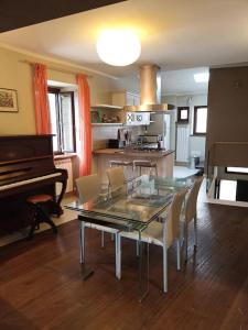 una sala da pranzo con tavolo in vetro e pianoforte di La Casa nel Borgo a Nocera Umbra