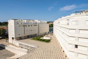 a view of two white buildings next to a street at Apartment Cosmopolitan in Zadar