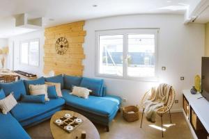 sala de estar con sofá azul y mesa en Villa Mon Rêve 12 pers à 500m de la plage, en Bréhal