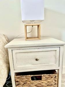 a white nightstand with a lamp on top of it at Le Loft de Barbizon in Barbizon