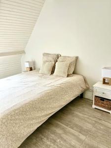 a white bedroom with a large bed with pillows at Le Loft de Barbizon in Barbizon