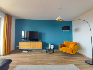 un soggiorno con sedia gialla e TV di Ferienwohnung Marin - neu a Kastav (Castua)