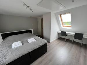 a bedroom with a bed with two chairs and a window at Ferienwohnung Neubörger mit Hottub in Neubörger