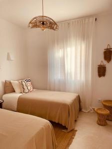 a bedroom with two beds and a chandelier at Amazing vue mer CASAZAZA in Benitachell