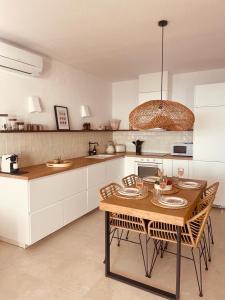a kitchen with a table and chairs in a kitchen at Amazing vue mer CASAZAZA in Benitachell