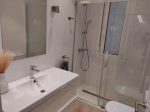 uma casa de banho branca com um lavatório e um chuveiro em Lujoso y amplio apartamento. em Leão