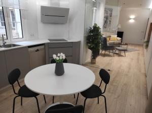 eine Küche und ein Esszimmer mit einem weißen Tisch und Stühlen in der Unterkunft Lujoso y amplio apartamento. in León