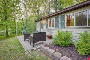 un patio con 2 sillas y una mesa frente a una casa en Harrison Cabin with Fire Pit and Elbow Lake Access! en Harrison