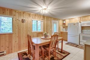cocina con mesa de madera, sillas y nevera en Harrison Cabin with Fire Pit and Elbow Lake Access! en Harrison