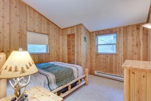 een slaapkamer in een blokhut met een bed en een lamp bij Harrison Cabin with Fire Pit and Elbow Lake Access! in Harrison