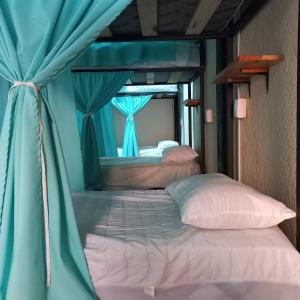 a bedroom with two beds with a blue curtain at Chante in Puerto Escondido