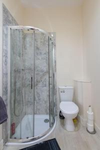 a bathroom with a shower and a toilet at CASTLEBANK HOUSE FLATS, DINGWALL in Dingwall +54 photos