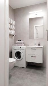 克拉科夫的住宿－Apartament 1A，白色的浴室设有洗衣机和水槽。