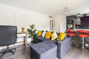 a living room with a couch and a kitchen at Mordenised 2 Bedroom House close to City Centre in Leeds