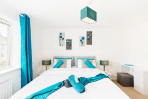 a bedroom with a bed with a blue bow tie on it at Spacious Group House for Contractors & Families - Ensuites, Parking & Netflix by DreamyPads in Bristol