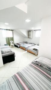 Habitación con 4 camas y una silla. en Pretty View Posada, en San Andrés
