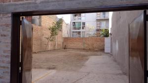 une porte ouverte menant à une cour vide dans un bâtiment dans l'établissement Céntrico 04, à General Roca